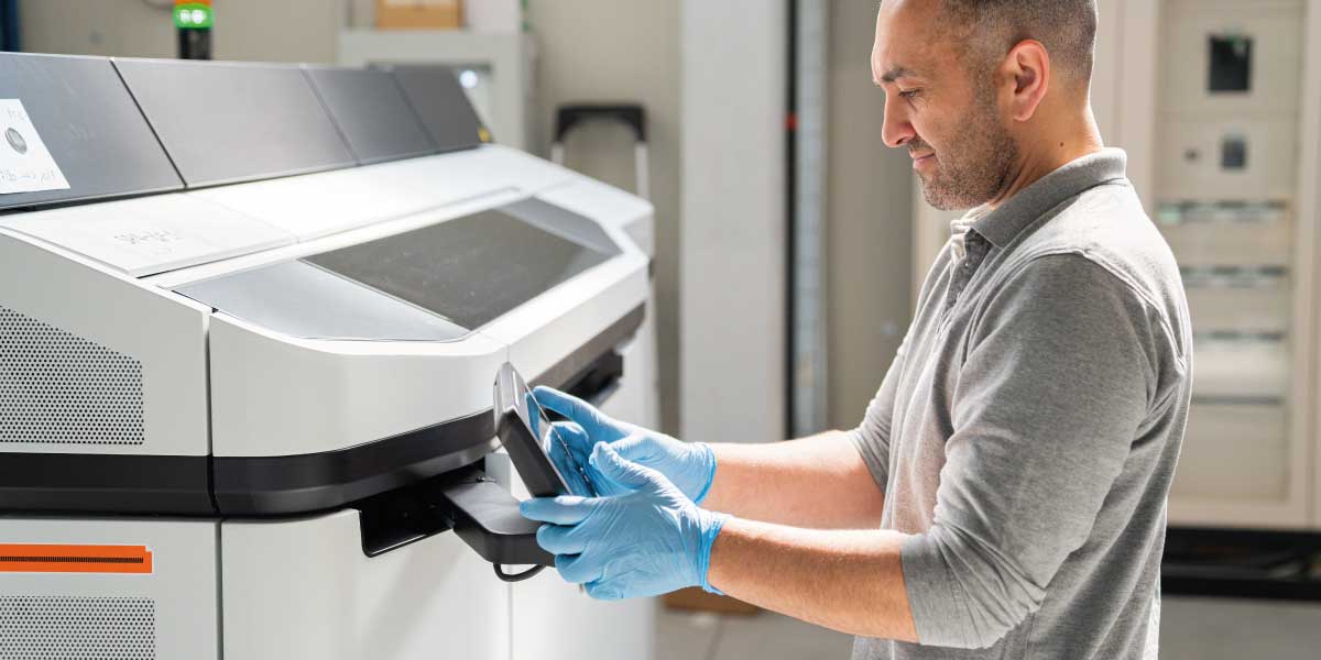 A man operates a 3d printing machine